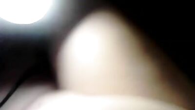 A woman uses a dildo with a cock ring on the bed