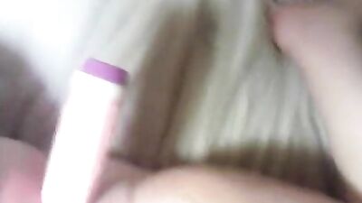 A woman uses a dildo with a cock ring on the bed