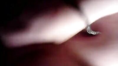 A woman uses a dildo with a cock ring on the bed