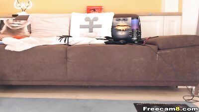 Brunette babe plays with two pink dildos on living room couch