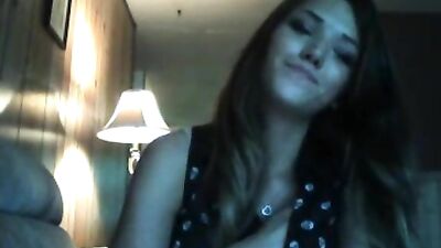 Brunette licks her lips while posing on the couch