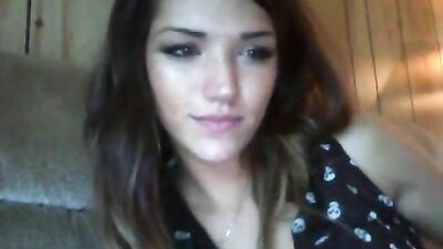 Brunette licks her lips while posing on the couch