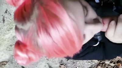 Pink haired emo teen blows outdoors